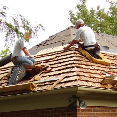 In addition to asphalt shingle roofing, we service and install wood shingles and wood shakes. In this photograph we are installing hand-split wood shakes, with a neatly mitered hip.